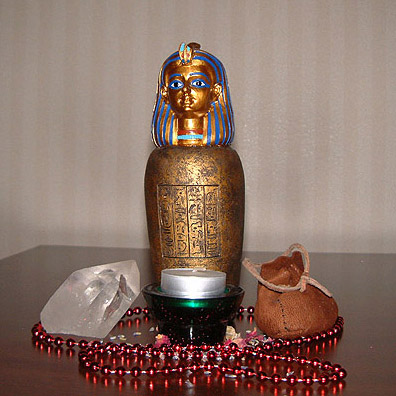 hotel room shrine with crystal, coptic jar, candle, medicine bag, beads, and herbs